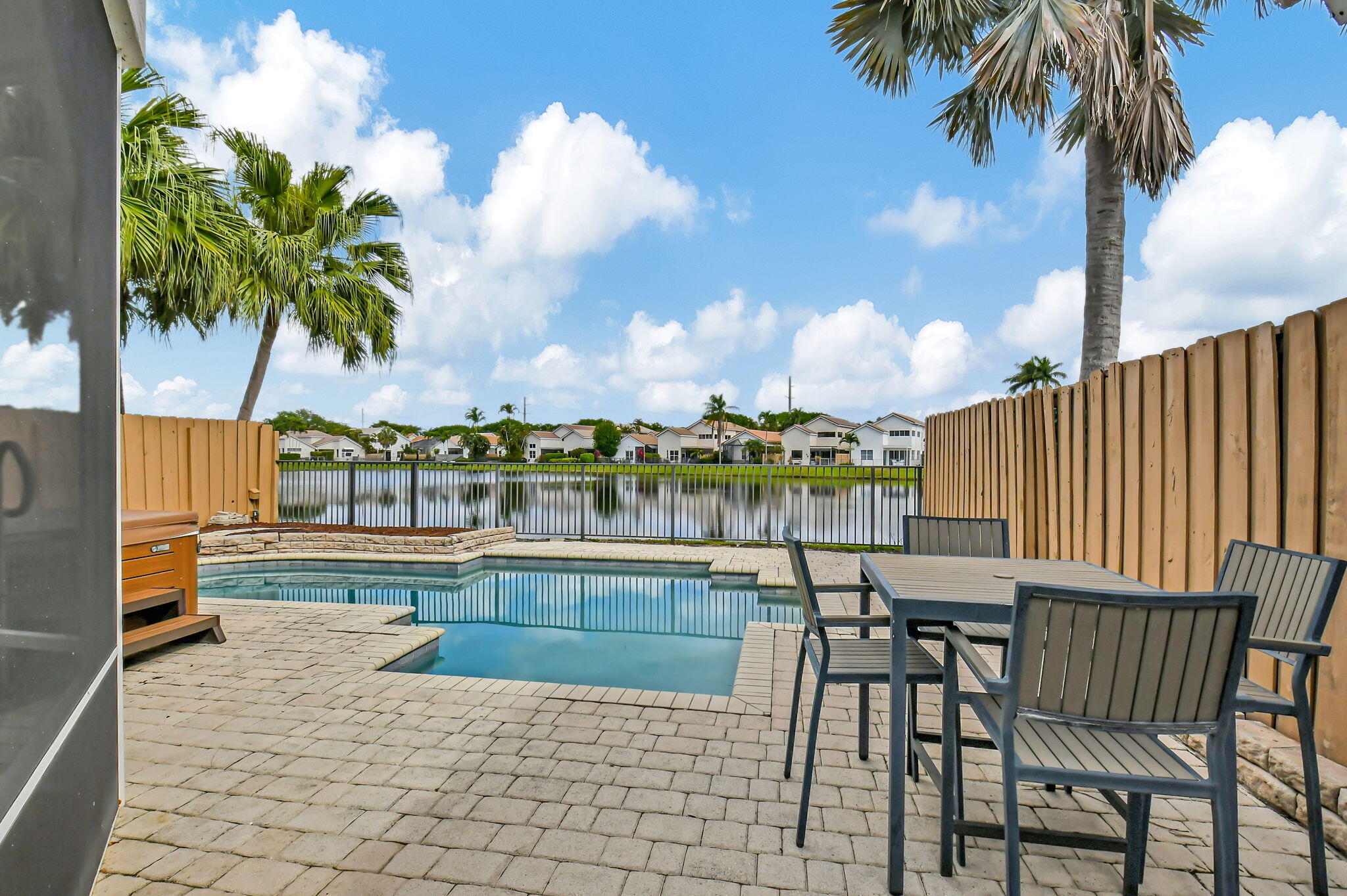 2469 Northwest 66th Drive Boca Raton, FL 33496 - Photo 28 of 45 a view of a swimming pool with a table and chairs