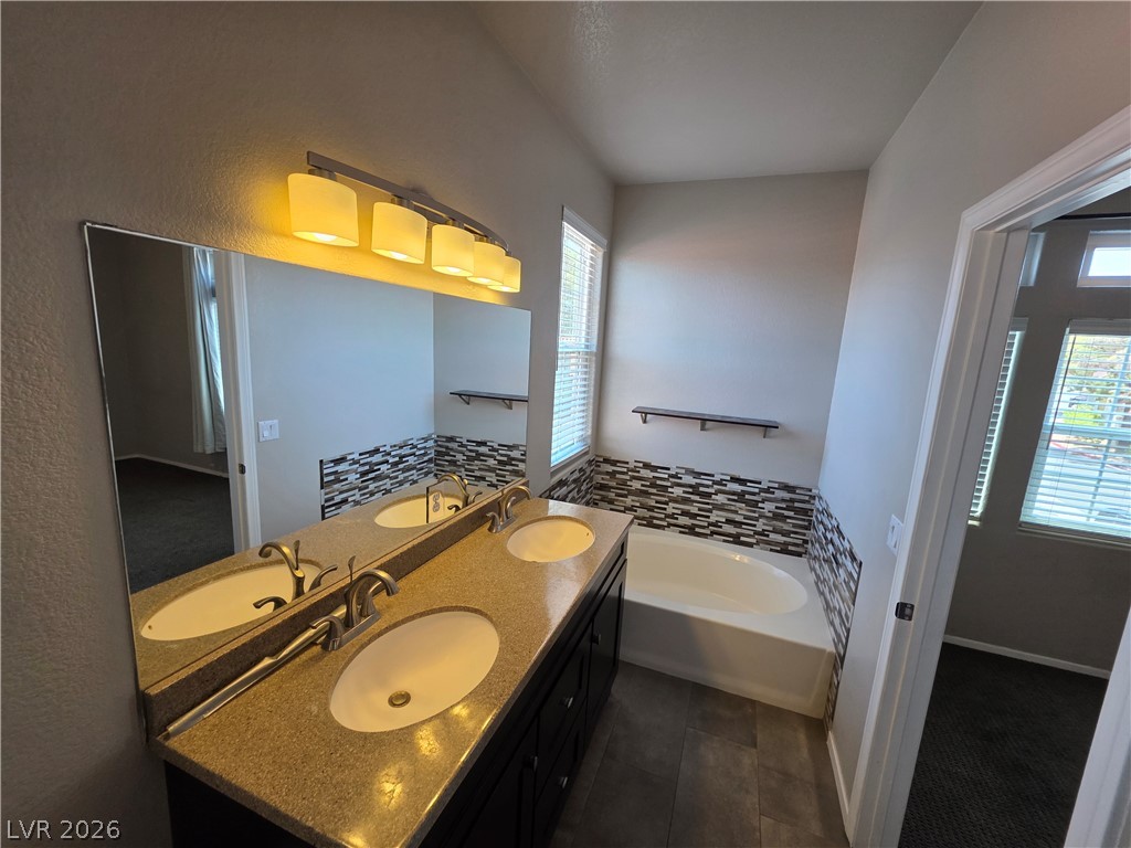2275 Ramsgate Drive Henderson, NV 89074 - Photo 65 of 84 Dual vanities with stone counters enhance this well-appointed primary bathroom.