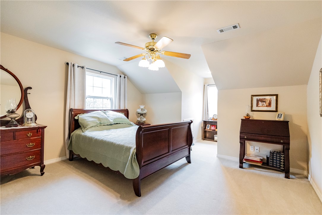14203 Greenridge Road Fayetteville, AR 72701 - Photo 21 of 25 Carpeted bedroom featuring a ceiling fan with integrated lighting, a window with curtains, and sloped ceiling details