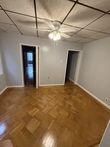 a view of an empty room with a chandelier fan