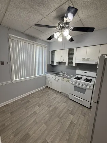 a kitchen with granite countertop a stove cabinets and wooden floor