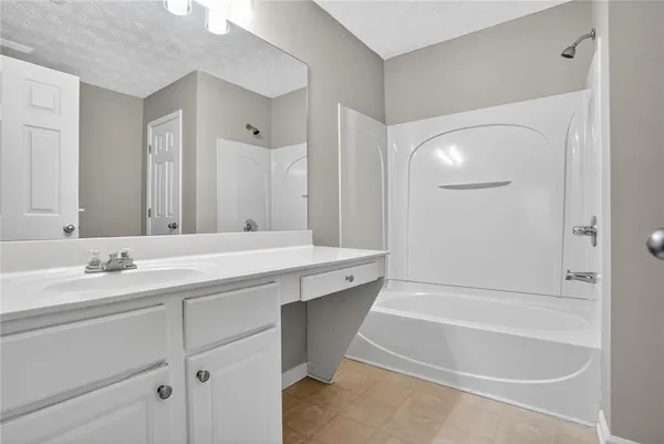 a bathroom with a tub a sink and a mirror