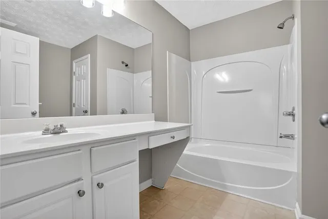 a bathroom with a tub a sink and a mirror