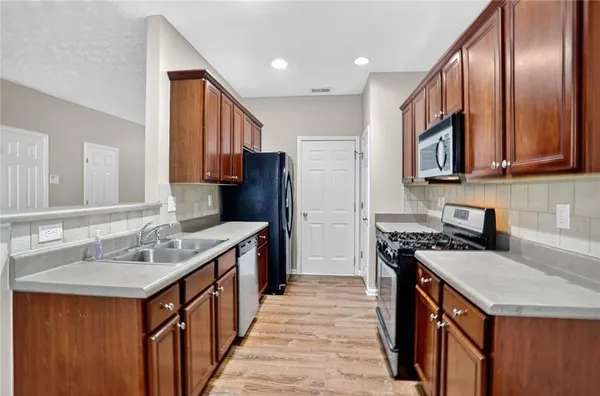 a kitchen with stainless steel appliances granite countertop a sink stove and refrigerator