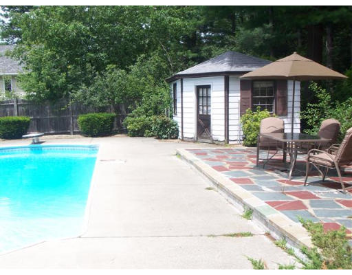 16 Governor Fuller Road Billerica, MA 01821 - Photo 18 of 21 a patio with a table and chairs under an umbrella