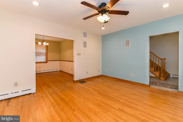 a view of an empty room with window and a chandelier fan