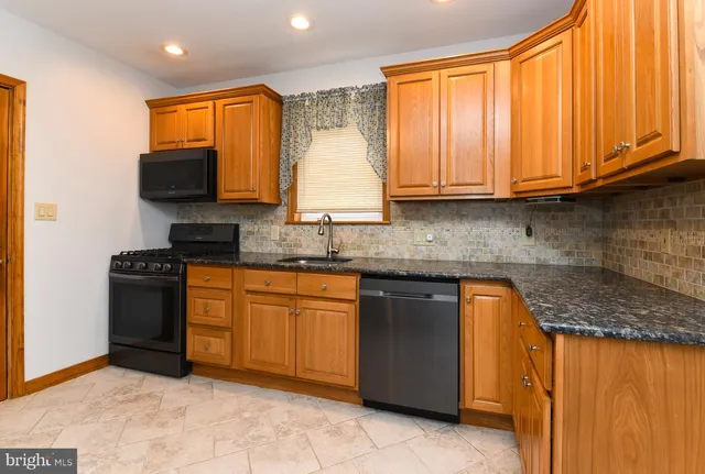 a kitchen with stainless steel appliances granite countertop a stove microwave and sink