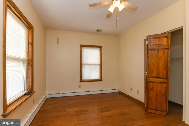an empty room with a window and a ceiling fan