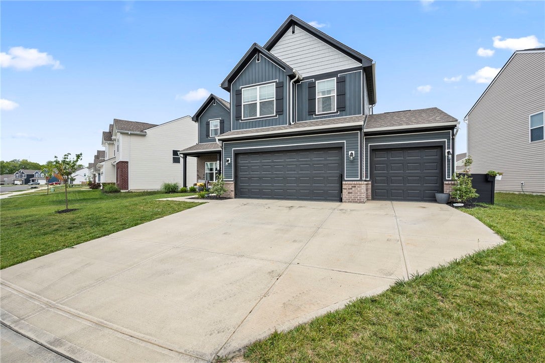 A contemporary suburban dwelling showcasing a dual-door garage and a neatly manicured lawn.