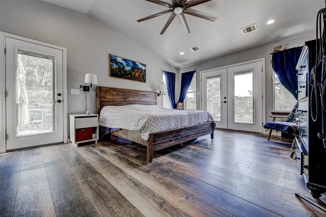a spacious bedroom with a bed a couch and a chandelier