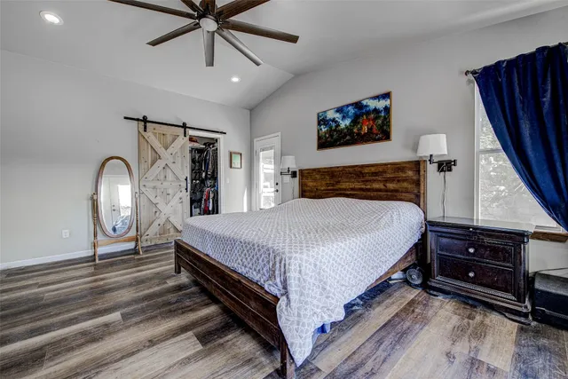 a bedroom with bed and wooden floor