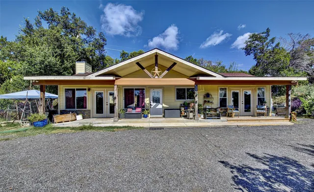 a patio with a table and chairs under an umbrella