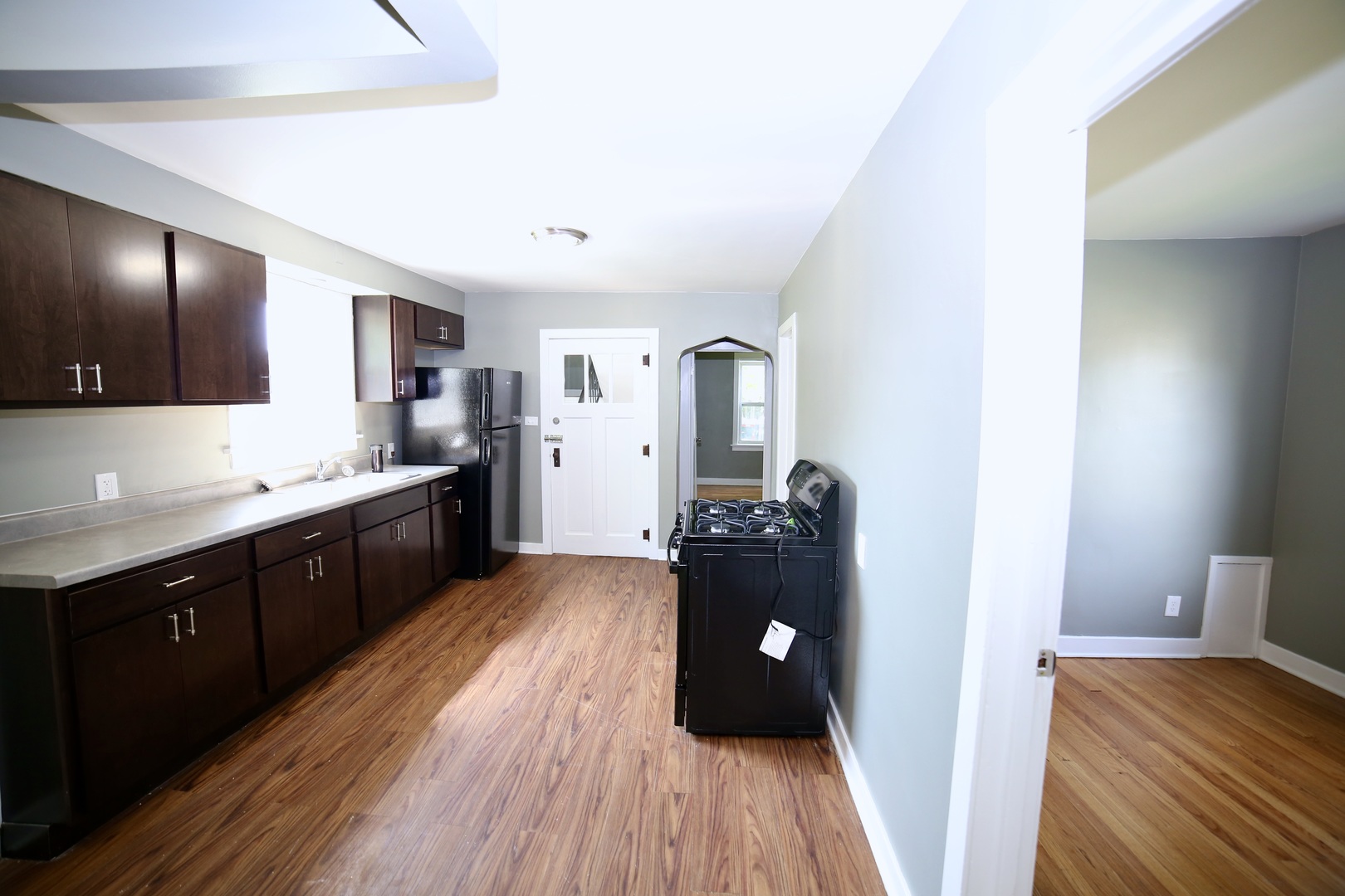 311 Pulaski Road Calumet City, IL 60409 - Photo 8 of 16 a kitchen with granite countertop a refrigerator a sink dishwasher and wooden cabinets with wooden floor