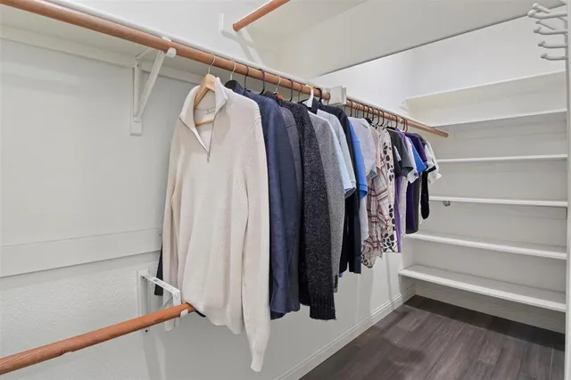 a view of walk in closet with clothes and shoes