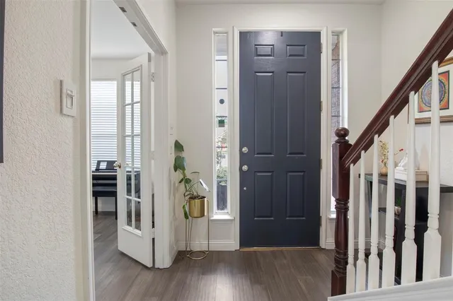 a view of a hallway with wooden floor and stairs