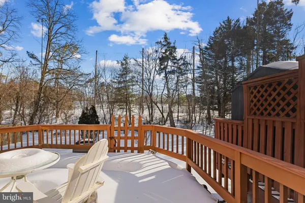 a view of a roof deck with wooden fence and trees