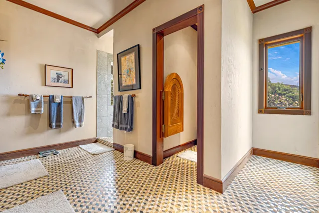 a bedroom with a bed a flat screen tv and a large window with the outer view