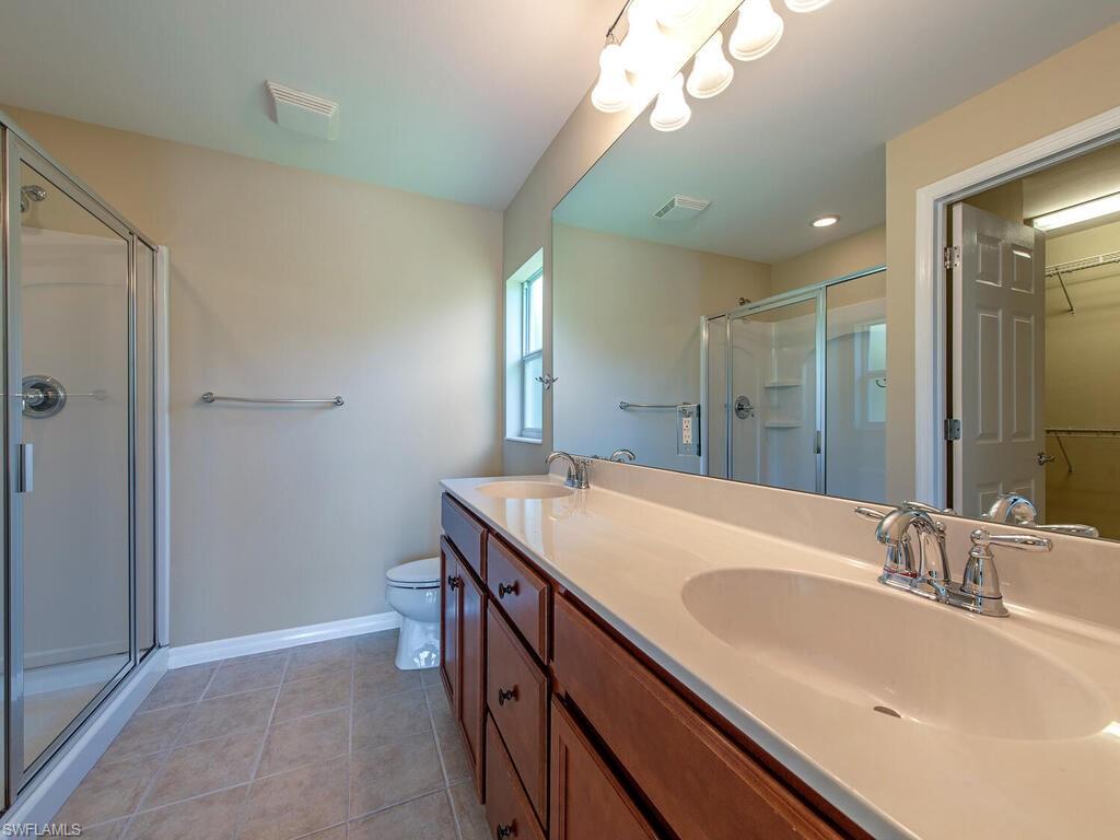 5784 Declaration Court Ave Maria, FL 34142 - Photo 6 of 21 a bathroom with a granite countertop sink a large mirror and a shower
