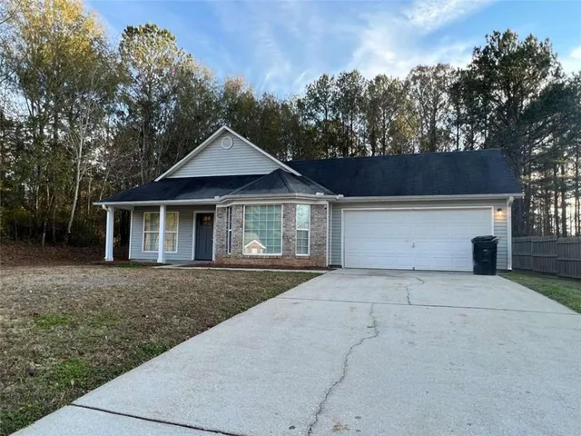 a front view of a house with yard and green space
