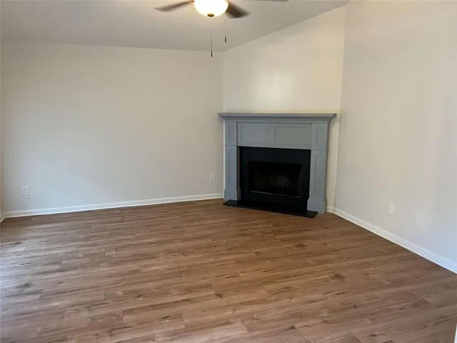 a view of empty room with wooden floor and fireplace