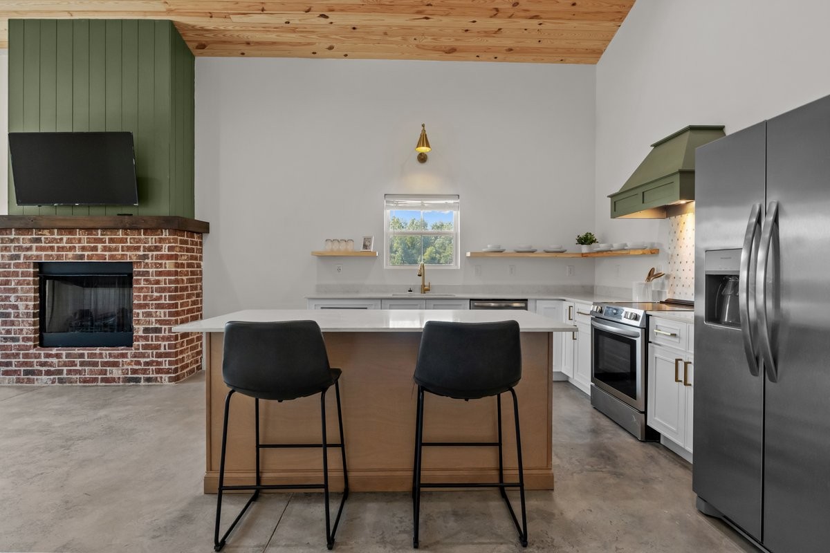 6405 Clydeton Road Waverly, TN 37185 - Photo 3 of 11 a kitchen with stainless steel appliances kitchen island granite countertop a stove a sink and a microwave