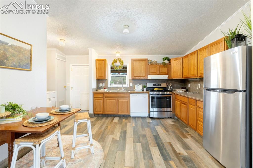 15345 Trigger Road Peyton, CO 80831 - Photo 12 of 26 a kitchen with granite countertop stainless steel appliances a sink and a refrigerator