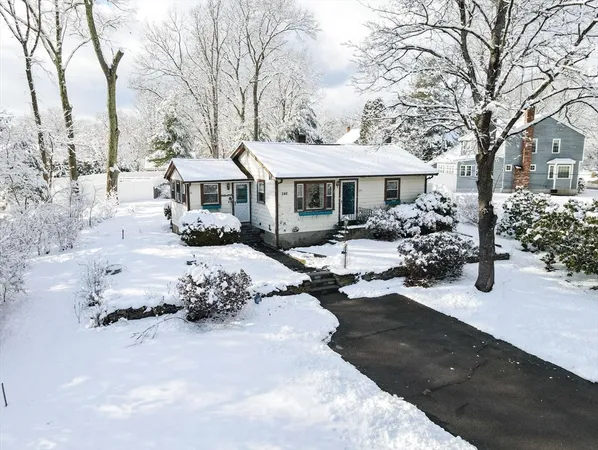 a front view of a house with a yard covered in snow