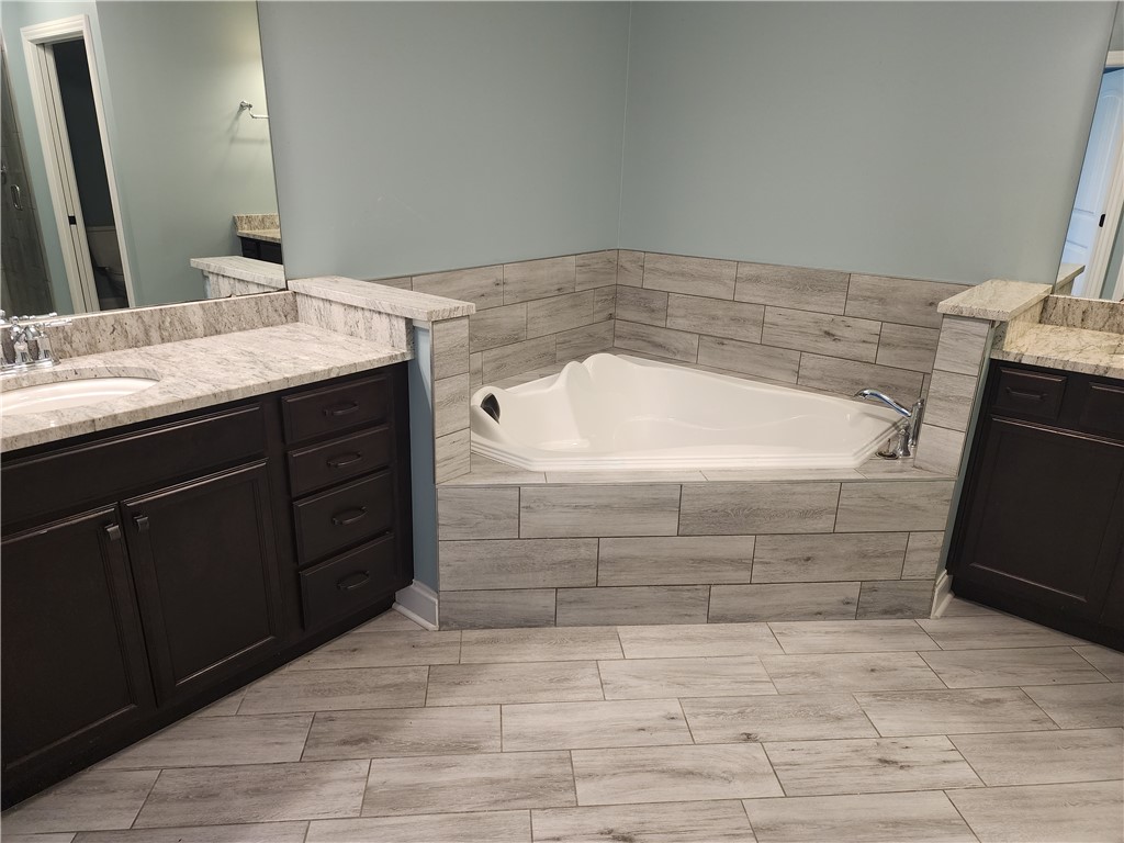 7441 Dodson Road Brookville, OH 45309 - Photo 22 of 50 This spacious bathroom offers a relaxing soaking tub, double vanity, and elegant tile flooring.