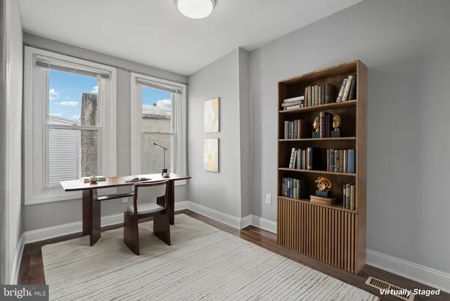 a view of a workspace with furniture and a window