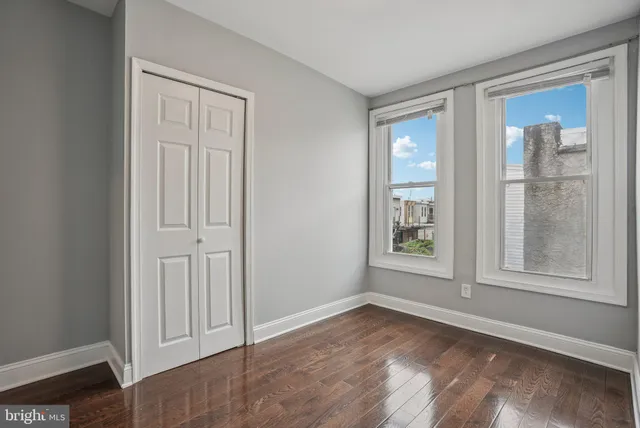 an empty room with windows and closet