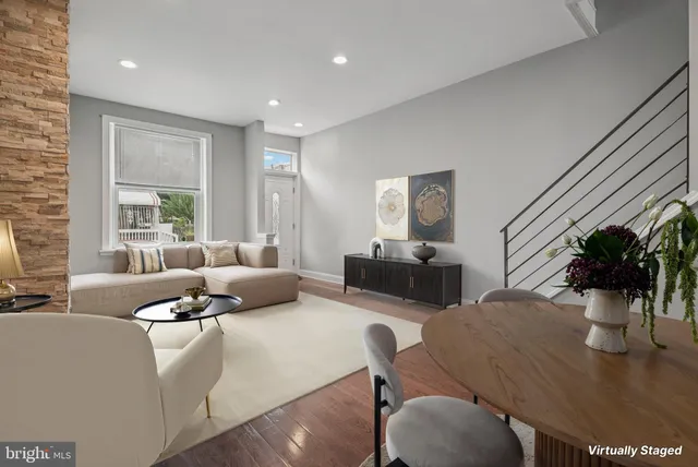 a living room with furniture kitchen view and a large window