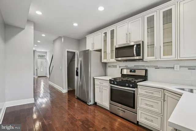 a kitchen with stainless steel appliances a refrigerator stove and microwave