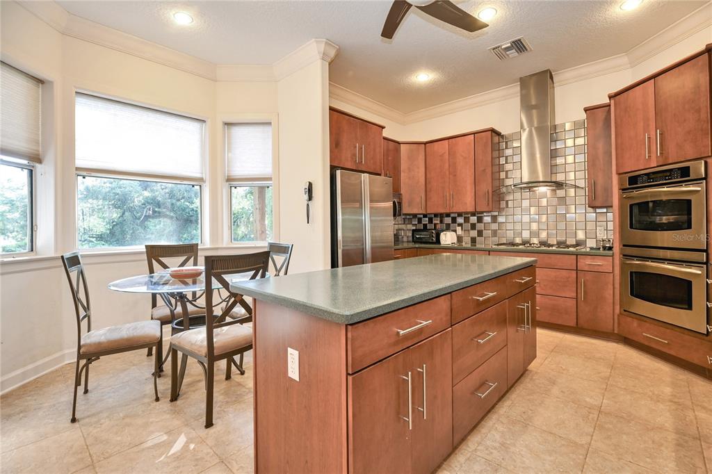 2299 North Bayou Point Inverness, FL 34453 - Photo 17 of 64 a kitchen with stainless steel appliances granite countertop a stove top oven a sink dishwasher a dining table and chairs with wooden floor