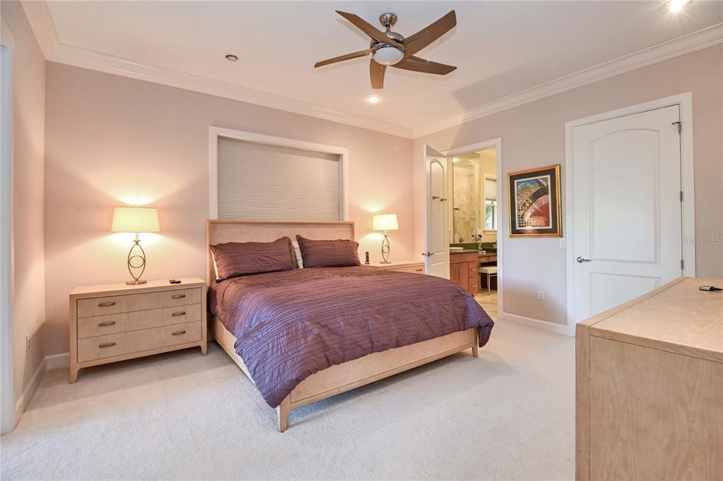 2299 North Bayou Point Inverness, FL 34453 - Photo 22 of 64 a spacious bedroom with a bed and a chandelier