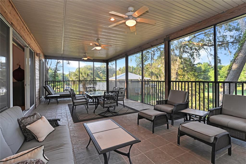2299 North Bayou Point Inverness, FL 34453 - Photo 10 of 64 a living room with furniture floor to ceiling windows and a table