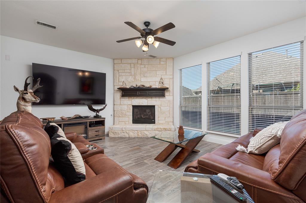 1008 Hummingbird Court Forney, TX 75126 - Photo 11 of 34 a living room with furniture ceiling fan and a flat screen tv