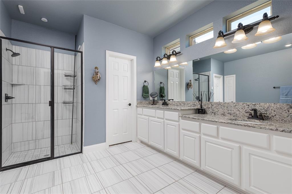 1008 Hummingbird Court Forney, TX 75126 - Photo 15 of 34 a bathroom with a granite countertop sink mirror and shower