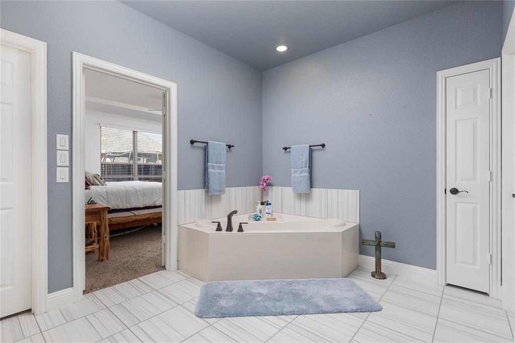 1008 Hummingbird Court Forney, TX 75126 - Photo 16 of 34 a en suite bathroom with a bathtub and next to a window
