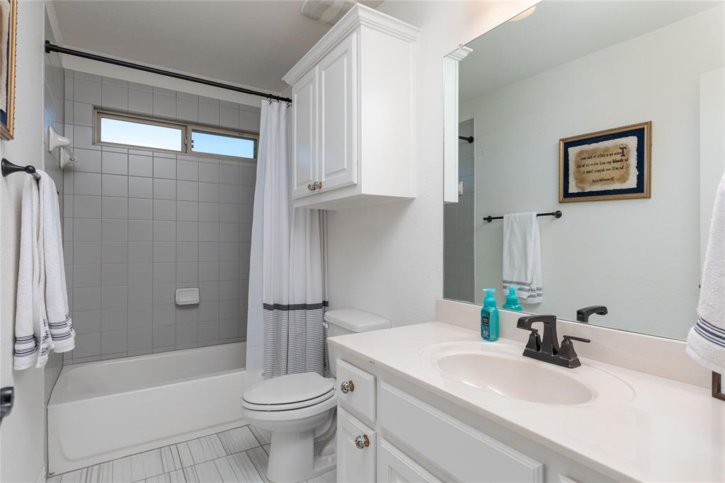 1008 Hummingbird Court Forney, TX 75126 - Photo 23 of 34 a bathroom with a sink a toilet and shower