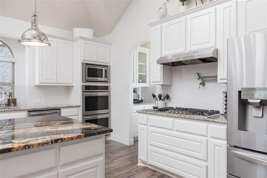 1008 Hummingbird Court Forney, TX 75126 - Photo 7 of 34 a kitchen with stainless steel appliances granite countertop a stove and a white cabinets