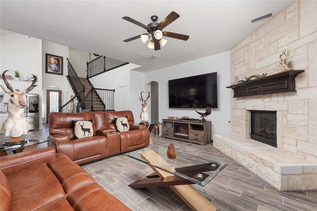 1008 Hummingbird Court Forney, TX 75126 - Photo 9 of 34 a living room with furniture a flat screen tv and a fireplace
