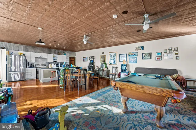 a kitchen with stainless steel appliances granite countertop a refrigerator a stove a sink dishwasher and white cabinets with wooden floor