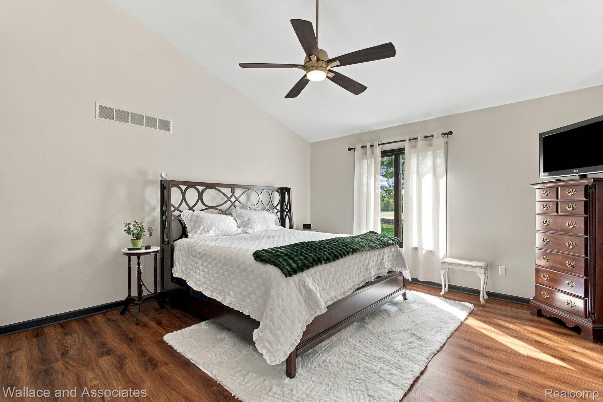 17076 27 Mile Road Ray, MI 48096 - Photo 23 of 63 Vaulted ceiling with a ceiling fan, window with dark trim, wood-finish flooring, and light-toned walls