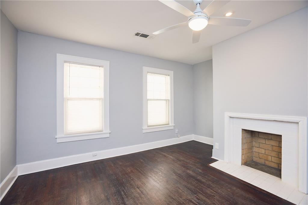 887 Myrtle Street Northeast, Unit 5 Atlanta, GA 30309 - Photo 2 of 11 an empty room with wooden floor windows and fireplace