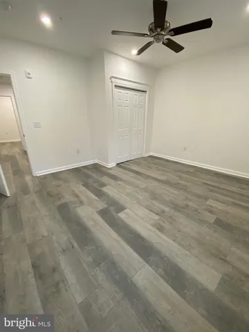 an empty room with a ceiling fan and windows