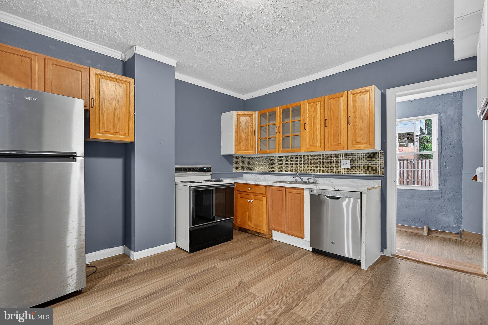 2202 Ashton Street Baltimore, MD 21223 - Photo 12 of 35 a kitchen with granite countertop wooden floors and stainless steel appliances
