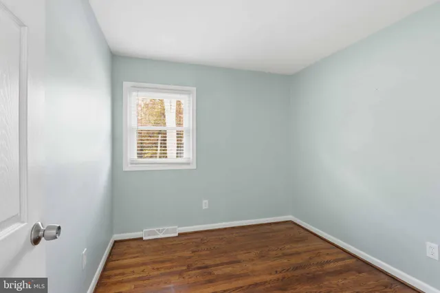 a view of a room with wooden floor and a window