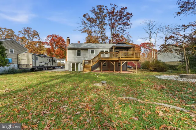 a view of a white house with a big yard and large trees