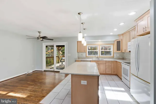 a large white kitchen with granite countertop a refrigerator and a stove