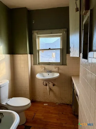a bathroom with a sink a toilet and mirror